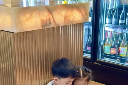 Children watching a smartphone together in a shop, illustrating young people and mobile content