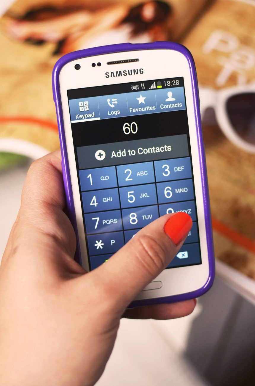 A shopper pays at a checkout by holding a smartphone near a payment terminal.