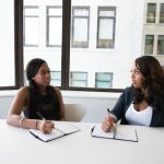 Two businesswomen discussing results during a meeting in a modern office