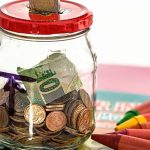 A piggy bank surrounded by coins and savings jars