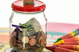 A piggy bank surrounded by coins and savings jars