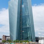 The stone facade of a central bank headquarters building in a financial district.