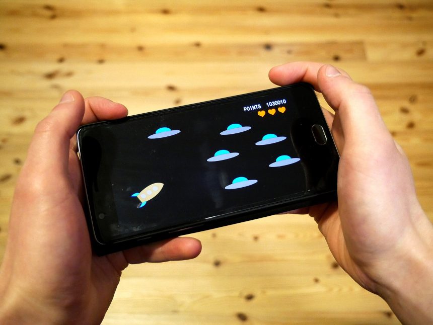 Hands holding a smartphone playing a mobile game